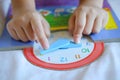 Kid play telling time game, young children to learn how to read an analog clock Royalty Free Stock Photo