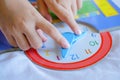 Kid play telling time game, young children to learn how to read an analog clock Royalty Free Stock Photo