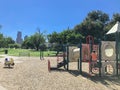 Empty kid playground surrounded by large trees with skyscrapers background in downtown Dallas, Texas, USA Royalty Free Stock Photo