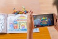 :kid playing Augmented Reality popup paintings of the color filled Taj Mahal via mobile Royalty Free Stock Photo