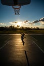 Kid playing basketball. Cute little boy child jumping with basket ball for shot silhouette on sunset. Royalty Free Stock Photo