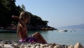 Kid Playing on Beach, Child Throwing Pebbles in Sea Waves on Seashore, Girl Plays Sunbathing on Coastline Shore in Summer Vacation Royalty Free Stock Photo