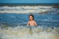 Kid playing on the beach on summer holidays. Kid swimming in sea with wawes. Royalty Free Stock Photo