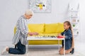 Kid playing checkers with senior grandparent Royalty Free Stock Photo