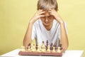 Kid playing chess. Boy looking at chess board and thinking about his strategy. Royalty Free Stock Photo