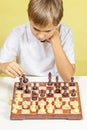 Kid playing chess. Boy looking at chess board and thinking about his strategy. Royalty Free Stock Photo