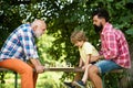 Kid Playing Chess. Handsome grandpa and grandson are playing chess while spending time together outdoor. Happy man Royalty Free Stock Photo