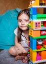 Kid is playing with Colorful lego bloks in her room. Close-up.