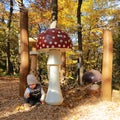 Kid playing by giant wooden mushrooms Royalty Free Stock Photo