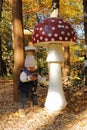 Kid playing by giant wooden mushrooms