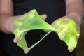 Kid Playing Handmade Toy Called Slime green color, Selective focus on Slime, Teenager having fun and being creative homemade slime