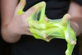 Kid Playing Handmade Toy Called Slime green color, Selective focus on Slime, Teenager having fun and being creative homemade slime