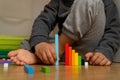kid with barefeet sitted on the floor playing with montessori math rods. Royalty Free Stock Photo