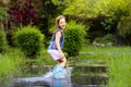 Kid with umbrella playing in summer rain Royalty Free Stock Photo