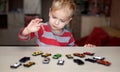 Kid playing with plenty of toy cars