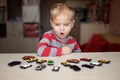 Kid playing with plenty of toy cars
