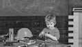 Kid playing with red screwdriver. Small boy in workshop. Tools lying on wooden table Royalty Free Stock Photo