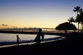 Kid playing at sunset with his family