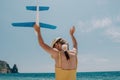 Kid playing with toy airplane. Children dream of travel by plane. Happy child girl has fun in summer vacation by sea and Royalty Free Stock Photo