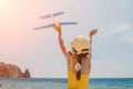 Kid playing with toy airplane. Children dream of travel by plane. Happy child girl has fun in summer vacation by sea and Royalty Free Stock Photo