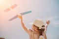 Kid playing with toy airplane. Children dream of travel by plane. Happy child girl has fun in summer vacation by sea and Royalty Free Stock Photo