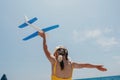 Kid playing with toy airplane. Children dream of travel by plane. Happy child girl has fun in summer vacation by sea and Royalty Free Stock Photo