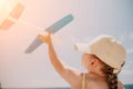 Kid playing with toy airplane. Children dream of travel by plane. Happy child girl has fun in summer vacation by sea and Royalty Free Stock Photo