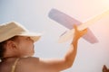 Kid playing with toy airplane. Children dream of travel by plane. Happy child girl has fun in summer vacation by sea and Royalty Free Stock Photo