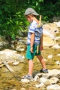 The kid plays near a mountain stream
