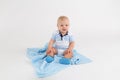 Kid on the plush blue blanket on the white background