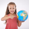 Kid, pointing to globe in studio with world, planets and city for education, geography and portrait. Student, girl child Royalty Free Stock Photo