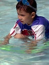 Young boy with goggles on his head in the pool