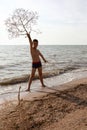 Kid posing with tumbleweed plant on beach of Azov sea Royalty Free Stock Photo