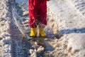 Kid in rainboots jumping in the ice puddle