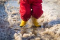 Kid in rainboots jumping in the ice puddle Royalty Free Stock Photo