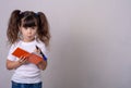 Surprised cute child writing in notebook using pencil, keeping mouth wide open. Four or five years old kid, isolated