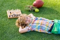 Kid relax in park, laying on grass, daydreaming. Clever kid thinking about chess.