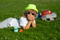 Kid relaxing on green meadow. Happy children rest fun outdoors. Kids relaxing in spring park. Boy lying on green grass. Royalty Free Stock Photo