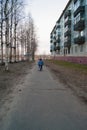 The kid rides alone on a bicycle on an empty spring street of the provincial city. Social distance due to quarantine, coronavirus Royalty Free Stock Photo