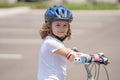 Kid riding on sporty bicycle in summer park. Child in safety helmet riding bike. Boy riding bike outside. Child in Royalty Free Stock Photo