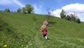 Kid Running Down the Hill in Mountains, Child Playing Outdoor in Camping, Rural, Rustic Girl Jumping on Meadow in Alpine Trip Royalty Free Stock Photo