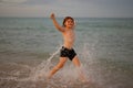 Kid running and splashing in the sea. Summer vacation. Child Running Along the summer beach. Happy excited little kid Royalty Free Stock Photo