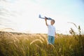 The kid runs with a toy plane. Son dreams of flying. Happy child, boy, runs on the sun playing with a toy airplane on Royalty Free Stock Photo