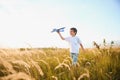 The kid runs with a toy plane. Son dreams of flying. Happy child, boy, runs on the sun playing with a toy airplane on Royalty Free Stock Photo