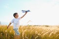 The kid runs with a toy plane. Son dreams of flying. Happy child, boy, runs on the sun playing with a toy airplane on Royalty Free Stock Photo