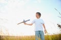 The kid runs with a toy plane. Son dreams of flying. Happy child, boy, runs on the sun playing with a toy airplane on Royalty Free Stock Photo