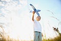 The kid runs with a toy plane. Son dreams of flying. Happy child, boy, runs on the sun playing with a toy airplane on Royalty Free Stock Photo