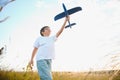 The kid runs with a toy plane. Son dreams of flying. Happy child, boy, runs on the sun playing with a toy airplane on Royalty Free Stock Photo