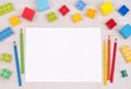 Kid`s desk with colorful building blocks and pencils, top view with copy space Royalty Free Stock Photo