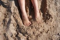 Kid`s feet on the sand on summer day. Barefoot on the beach. Royalty Free Stock Photo